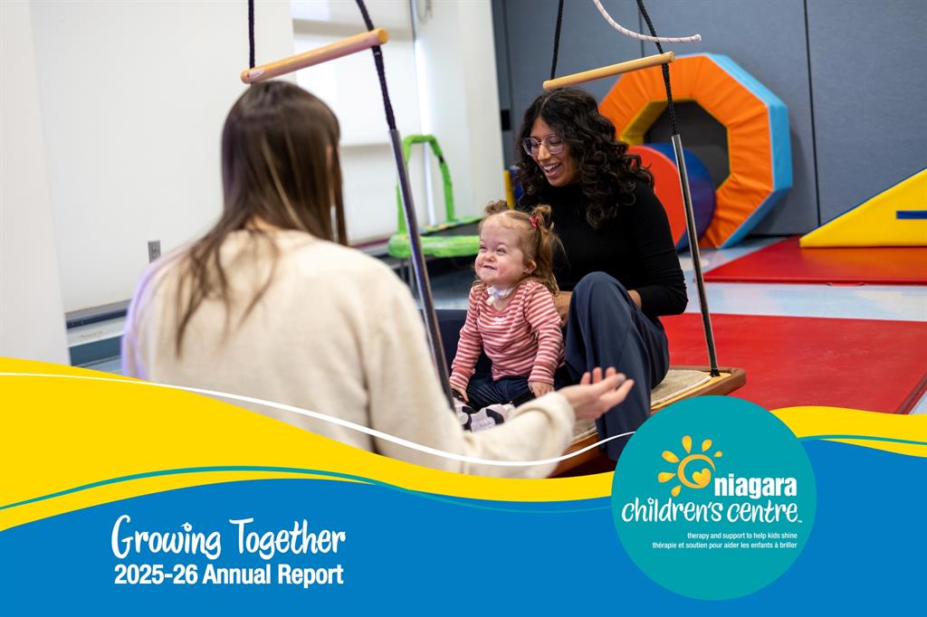 Two women and a child on swing in therapy room