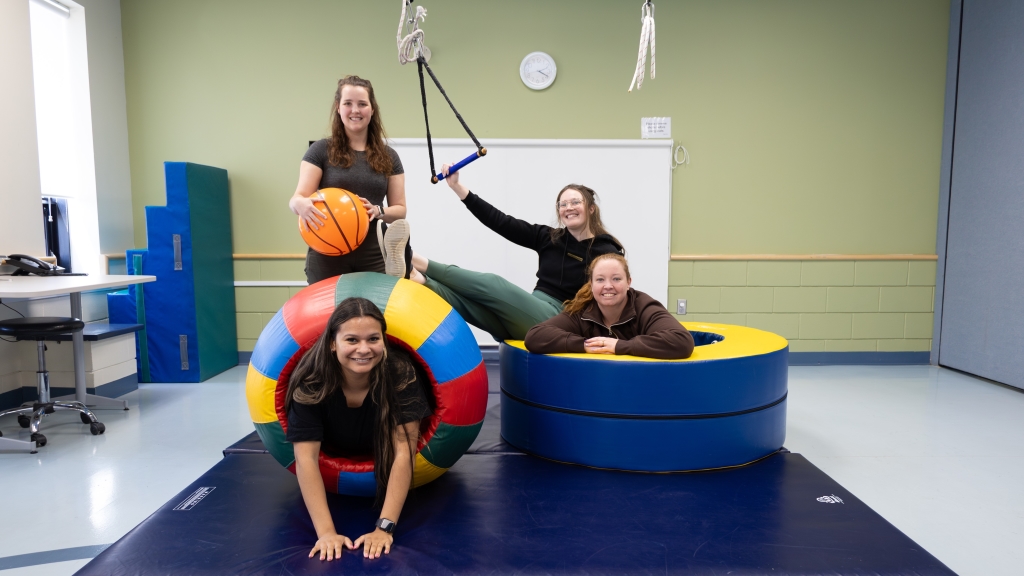 Four women poses with therapy equipment