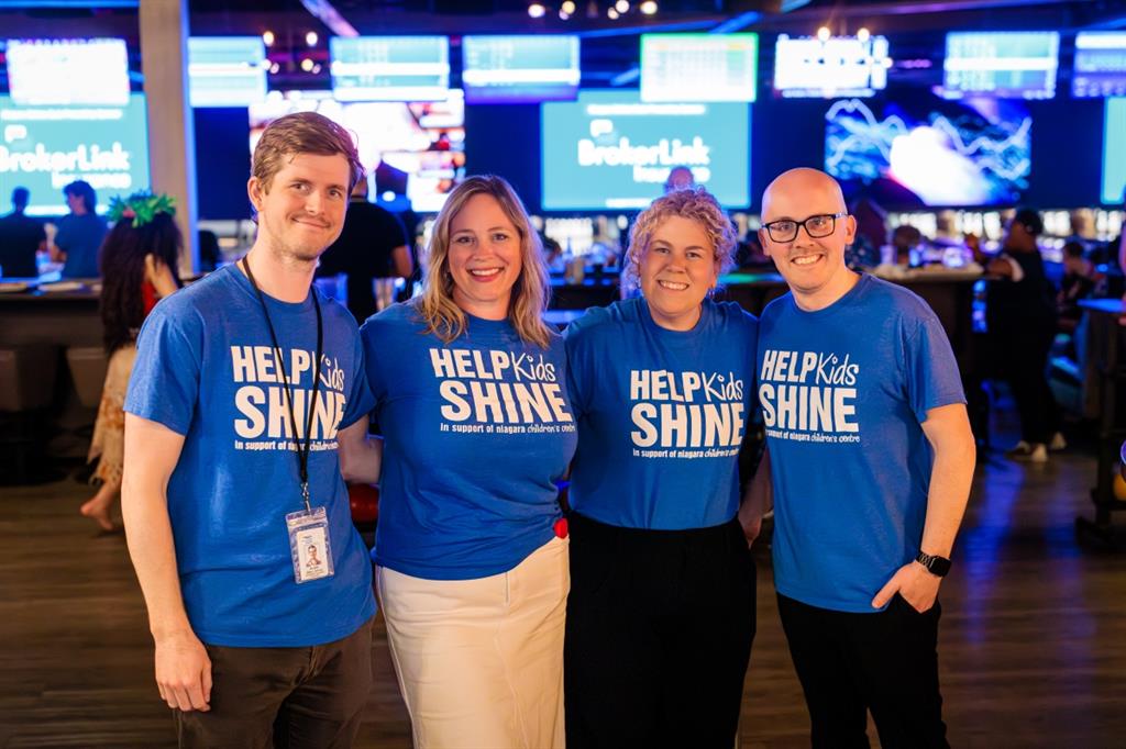 Group of four people posing for photo in bowling alley