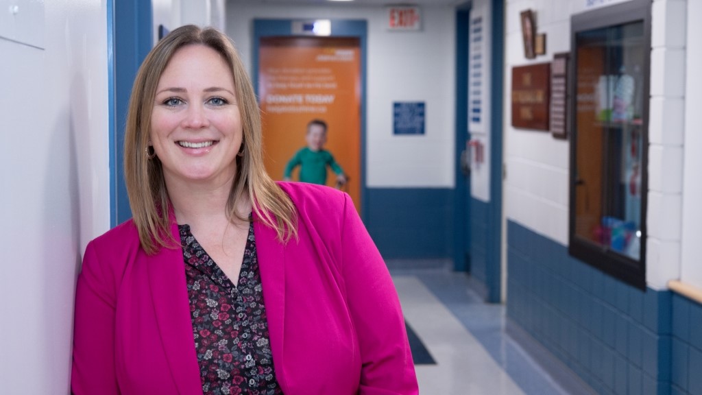 Women in pink blazer stands in hallway