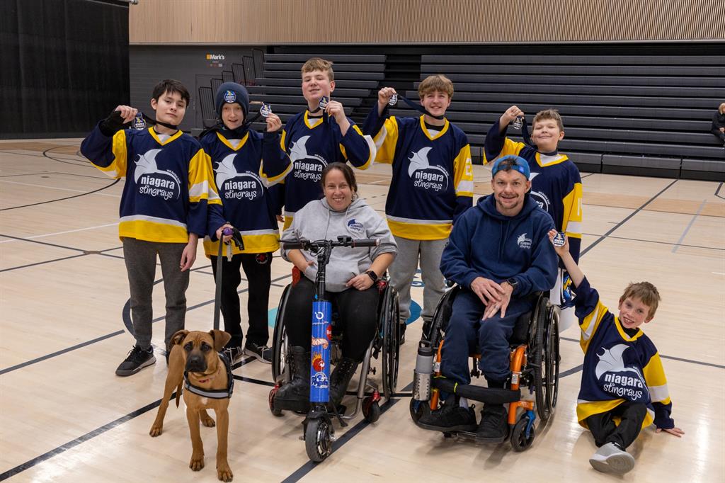 Team holding up medals with coaches and a dog