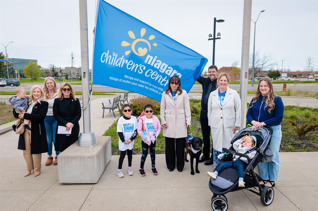 A small group holding a Niagara Children's Centre flag outside