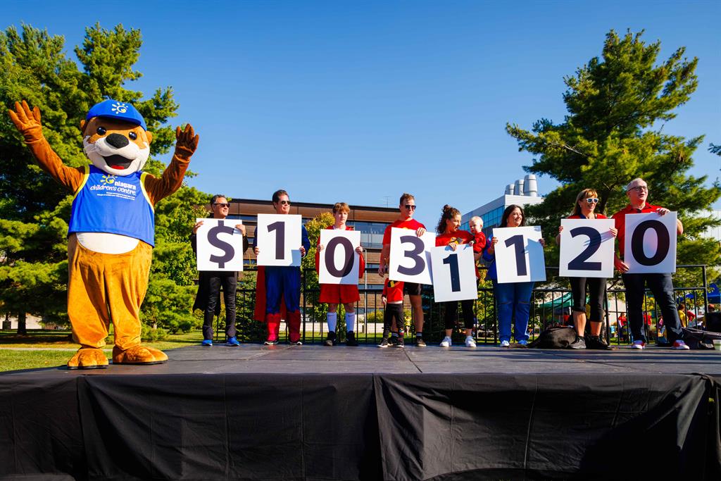 Group of people holding large numbers on a stage