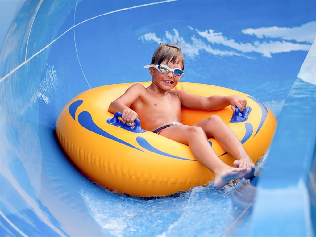 Boy riding water park water slides