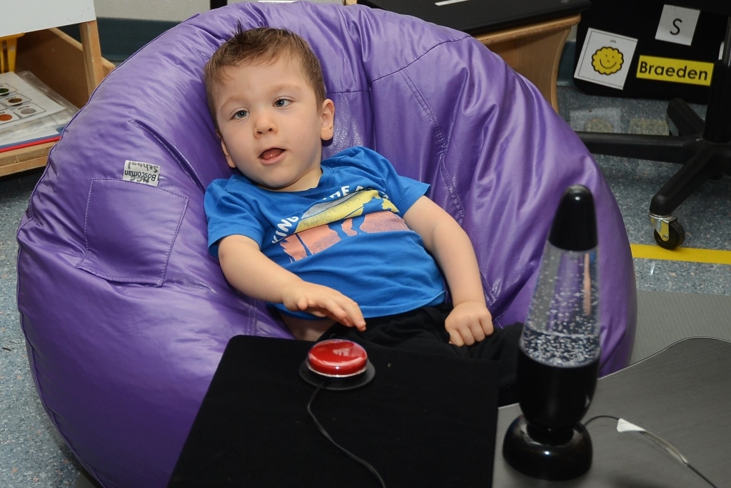 Young boy on purple bean bag chair
