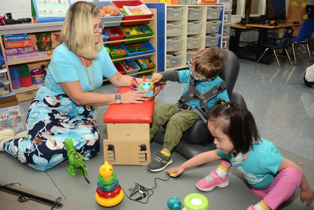 Female teacher working with two students in classroom