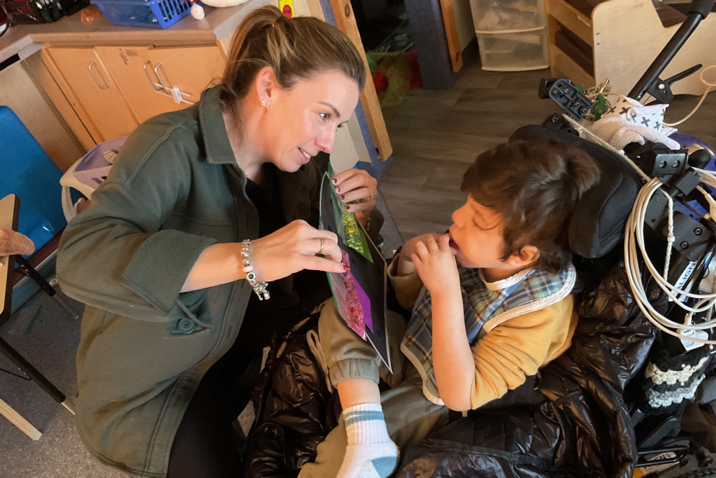 Female teacher showing picture to male student